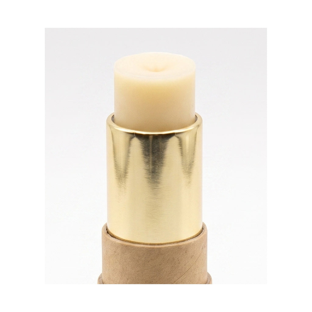 Floof Shop paw balm twist-up stick, cream balm and gold barrel in a kraft tube, on white