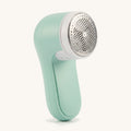Mint cordless pet hair remover on a warm off-white background