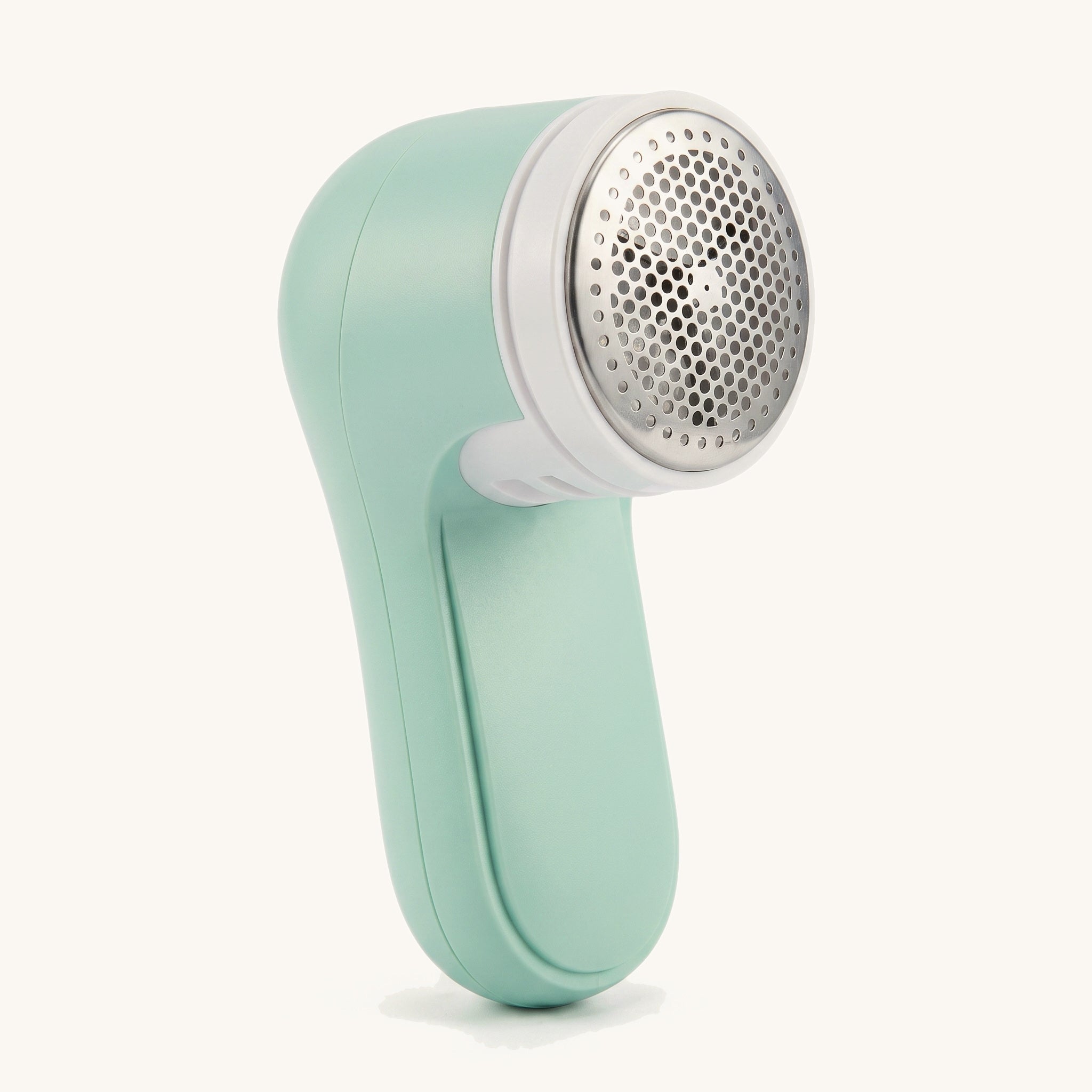Mint cordless pet hair remover on a warm off-white background